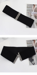 Detail of black wide elastic waist belt featuring vintage silver metal interlocking buckle