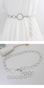 Detailed view of silver hexagonal chain belt on white dress and still life display