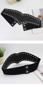 Détail d'une ceinture large élastique noire avec œillets métalliques et boutons-pression