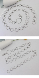 Detailed macro view of silver hexagonal link metal chain belt with lobster clasp closure