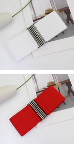 Detail of elastic waist belts with vintage metal interlocking buckles in red and white