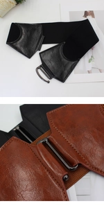 Détail d'une large ceinture élastique pour femme avec boucle en métal noir et similicuir