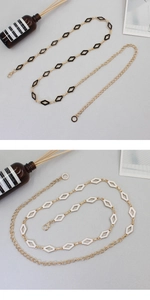 Detail of elegant gold alloy waist chain featuring black and white diamond enamel accents