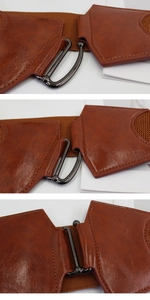 Détail d'une ceinture large marron élastique avec boucle en métal noir et similicuir fini