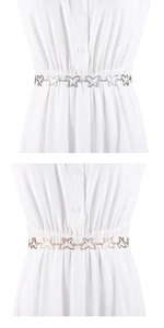 Détail de la ceinture chaîne avec motif papillon ajouré en coloris doré et argenté