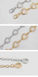 Détail de ceintures en chaîne de fleurs métalliques avec fermoirs mousqueton or et argent