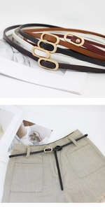 Detail of slim leather belts with gold oval buckles in black, brown, and white colors