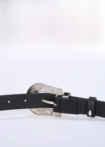 Detail de la ceinture en similicuir vintage avec boucle argentee gravee style western