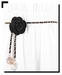 Detail of black camellia flower waist chain with gold metal and leather links