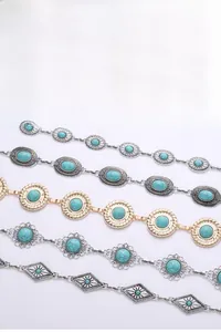 Detailed view of silver bohemian metal waist chains with turquoise stones and floral patterns