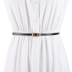 Minimalist black thin leather belt with golden oval buckle worn on a white dress