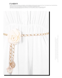 Detail of camellia metal chain belt with cream fabric flower on a white dress