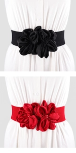 Detail van elastische taillebanden in zwart en rood met grote stoffen bloemdecoraties