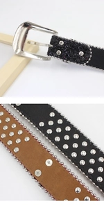 Detail of punk rhinestone skull belt buckle with silver rivets and metal accents