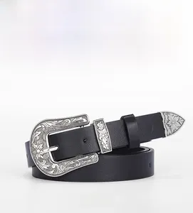 Détail d'une ceinture en cuir noir vintage avec boucle argentée ciselée et embout métallique