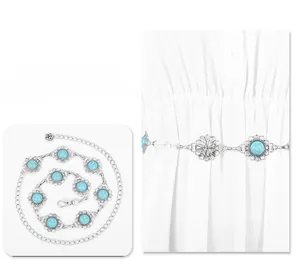 Detail view of silver metal waist chain with floral turquoise inserts and rose charm