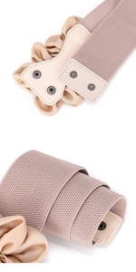 Detail van abrikooskleurige elastische riem met drukknoopsluiting en ruches