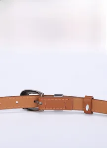 Detail view of brown leather belt with retro silver buckle and fine edge stitching