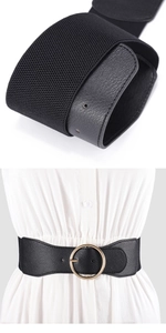 Close-up of black elastic waist belt with round gold buckle and lychee leather texture