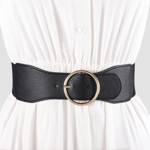 Women's wide black elastic waist belt with large round gold buckle on white dress