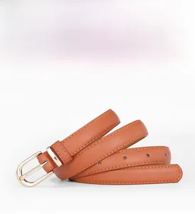 Détail d'une ceinture fine en cuir marron avec 12 trous et boucle en U dorée