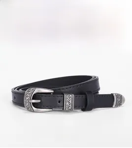Detail of vintage silver engraved buckle and tip on a black slim leather waist belt