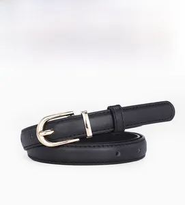 Détail de la ceinture fine en cuir noir avec boucle ovale dorée et texture grainée