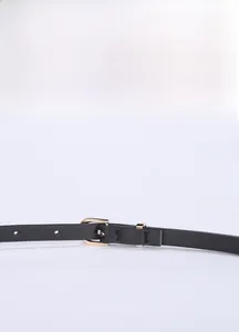 Detail of minimalist black thin leather belt with a golden horseshoe buckle