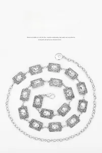 Macro detail of silver vintage chain belt with rhinestone insets and hollow metal pattern