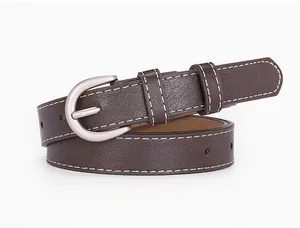 Détail de la ceinture en cuir café avec surpiqûres blanches et boucle argentée mate