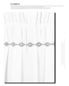 Detail of silver floral waist chain with sparkling rhinestones on white pleated fabric
