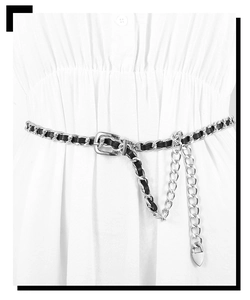 Détail de la ceinture chaîne tressée en métal et cuir noir sur robe blanche