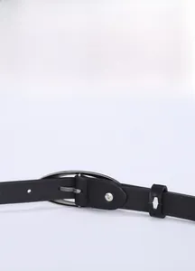 Détail de la ceinture en cuir noir avec boucle ovale argentée et coutures fines de précision