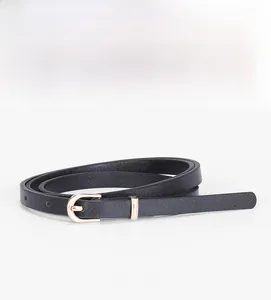 Detail of slim black matte leather belt with a refined golden metal buckle closure