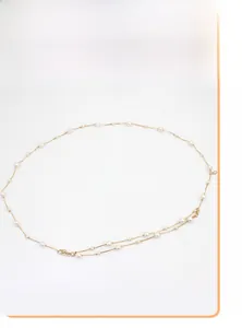 Detailansicht der goldfarbenen Metall-Kettengürtel mit eleganten weißen Perlen und Haken