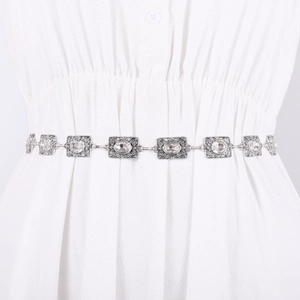 Elegant silver metal waist chain with rhinestones and vintage texture on white dress