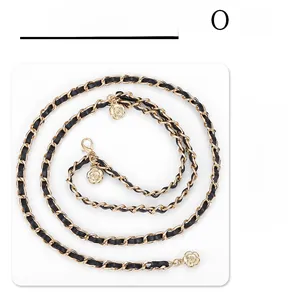 Detail of gold metal chain woven with black leather and camellia flower charms