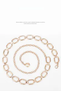 Détail d'une ceinture chaîne en métal doré avec maillons ovales et fermoir mousqueton