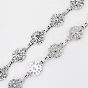 Silver flower waist chain with rhinestone embellishments on a white background
