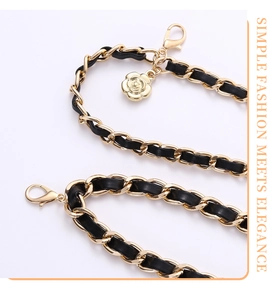 Detail of black leather and gold metal chain belt featuring a 3D rose flower pendant