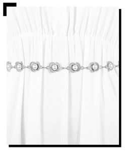 Close-up of silver metal waist chain with hollow flower pendants and white pearls