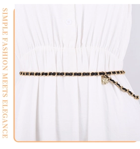Detail of elegant gold metal chain belt with black leather weave and rose pendant decoration