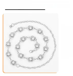 Detail of silver metal waist chain with carved flower links and inlaid pearls