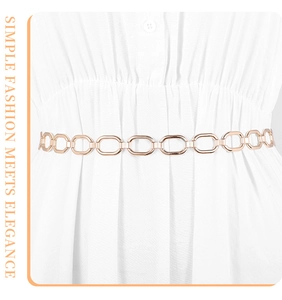 Détail d'une chaîne de taille en métal à maillons ovales sur une robe blanche élégante