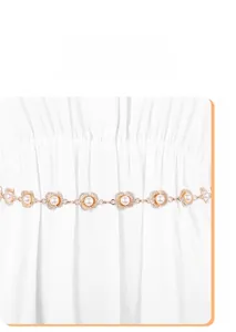 Detail of gold metal waist chain with plum blossom patterns and pearls on white dress