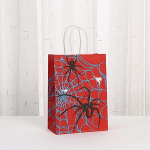 Detailed close-up of red Halloween spider gift bag with twisted paper handles and web print