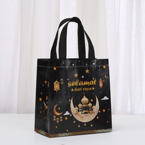 Dettaglio del sacchetto regalo Hari Raya con motivi dorati di luna e moschea su nero