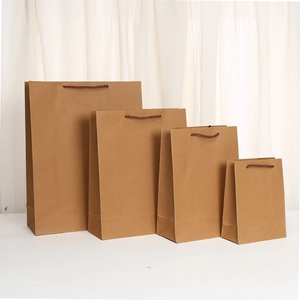 Set of four natural kraft paper shopping bags with handles in various sizes for gifts