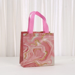 Detail of pink marble gift bag with gold glitter lines and fabric ribbon handles
