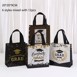 Detail showing non-woven graduation gift bags with gold lettering and black handles